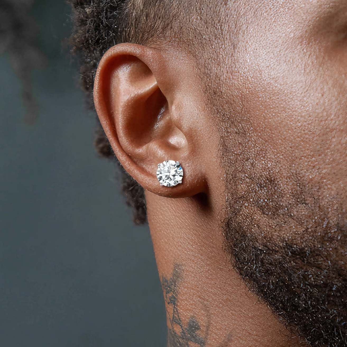 Close-up of a man wearing a diamond earring with a blurred background
