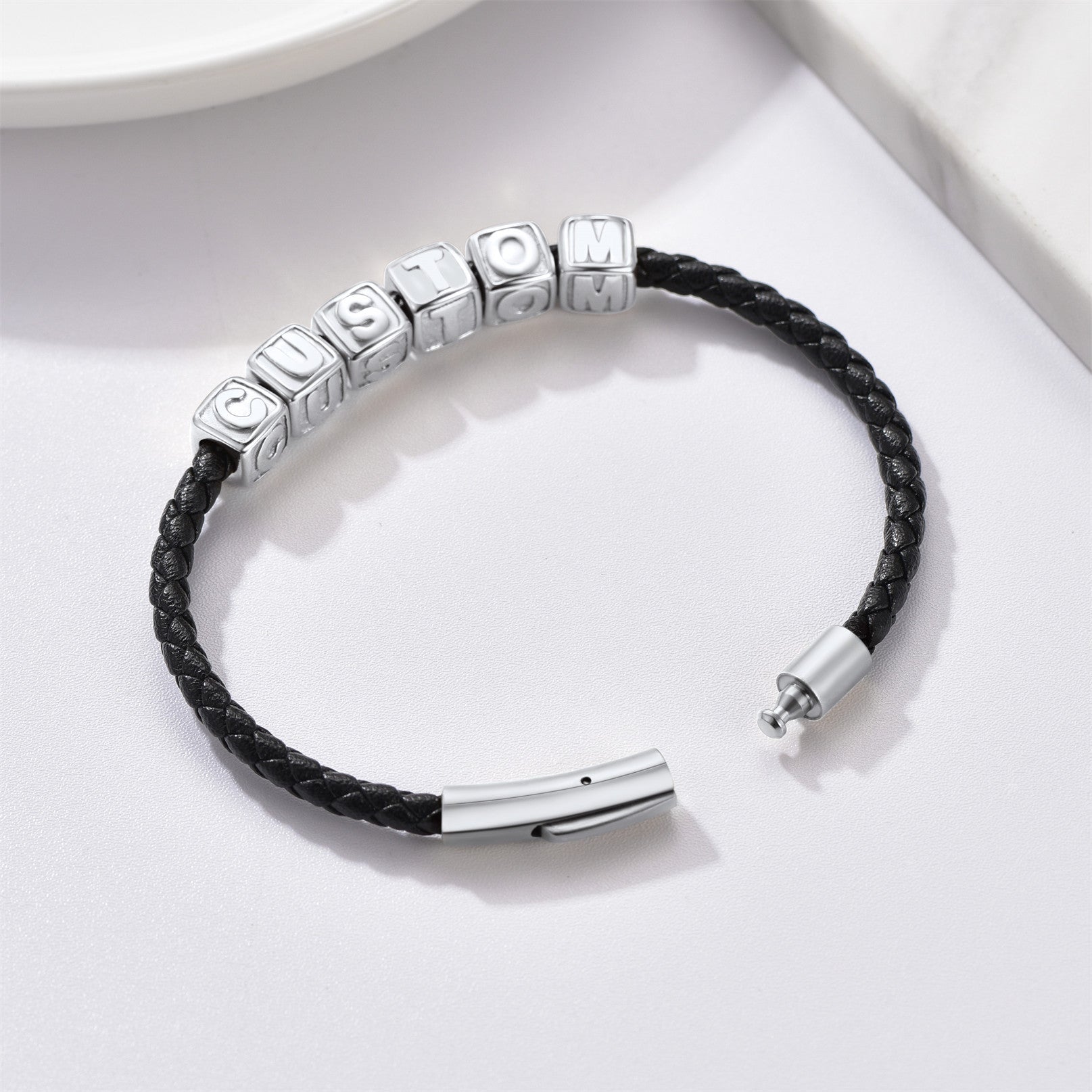 Black leather bracelet with silver beads on a white background