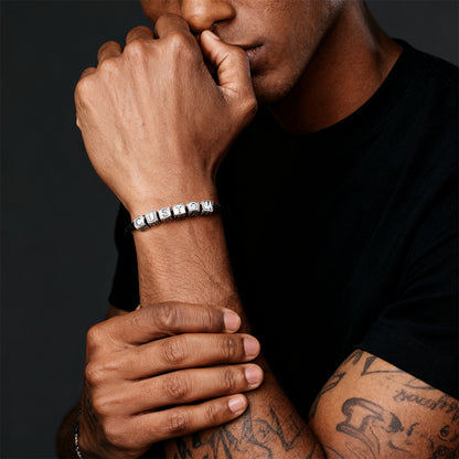 Person wearing a silver bracelet with dark background