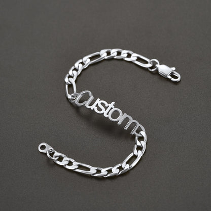 Silver chain bracelet with 'Custom' engraving on a dark gray background