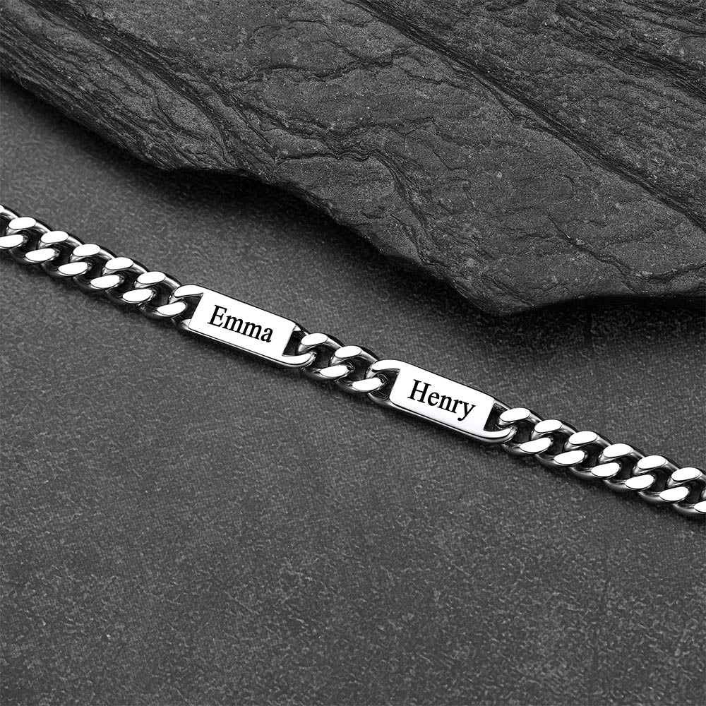 Silver chain bracelet with engraved names on a dark stone surface
