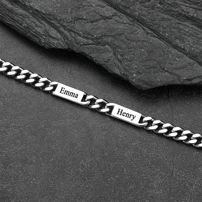 Silver chain bracelet with engraved names on a dark stone surface