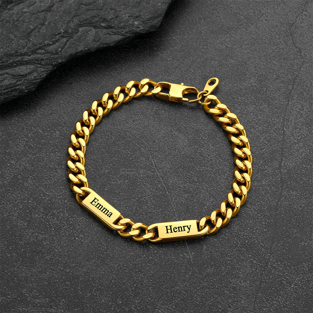 Gold chain bracelet with engraved names on a dark stone surface