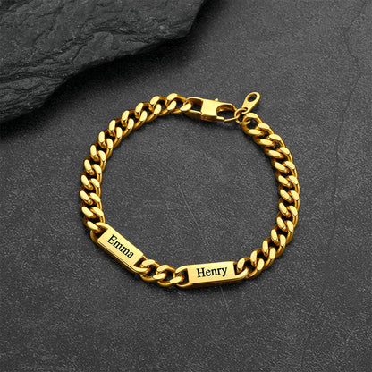 Gold chain bracelet with engraved names on a dark stone surface