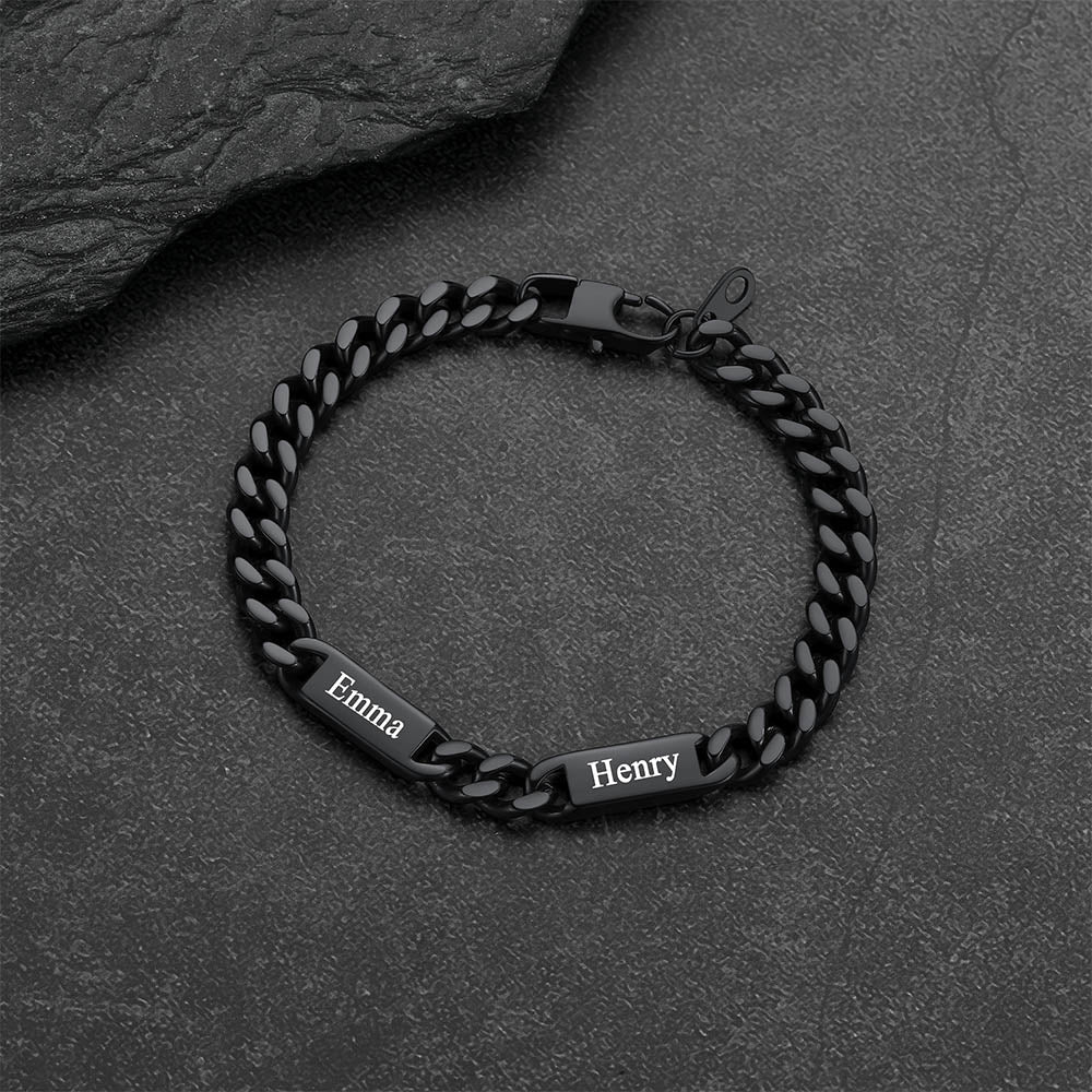 Black chain bracelet with engraved names on a dark stone surface