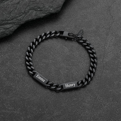 Black chain bracelet with engraved names on a dark stone surface
