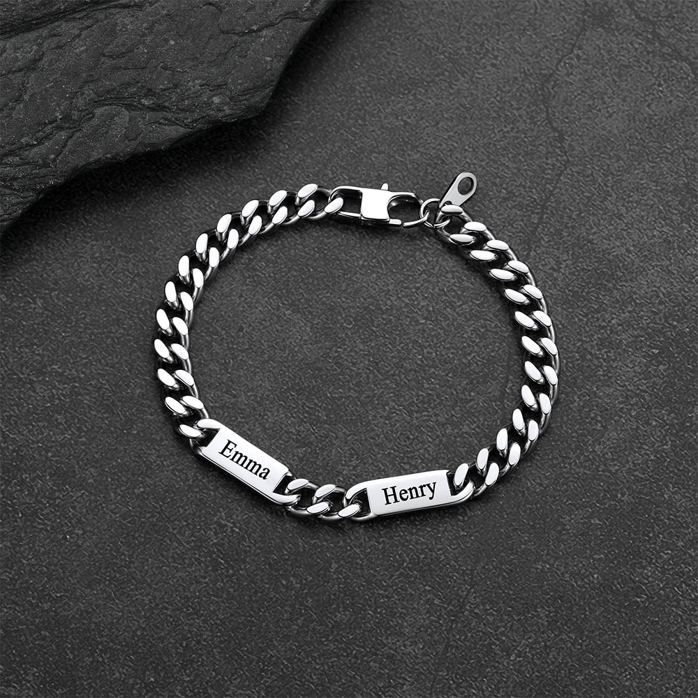 Silver chain bracelet with engraved names on a dark stone surface