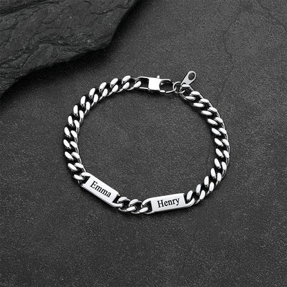 Silver chain bracelet with engraved names on a dark stone surface