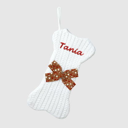 White textured Christmas stocking with a red sequin bow and 'Tania' embroidered on a light gray background