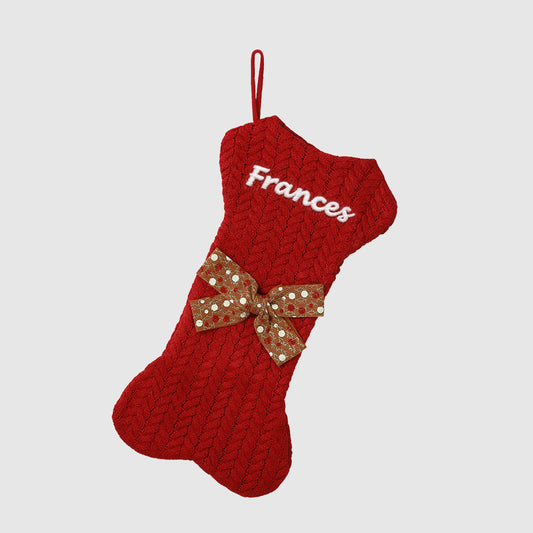 Red knitted Christmas stocking with a brown bow and 'Frances' embroidered on a light gray backgroundimg