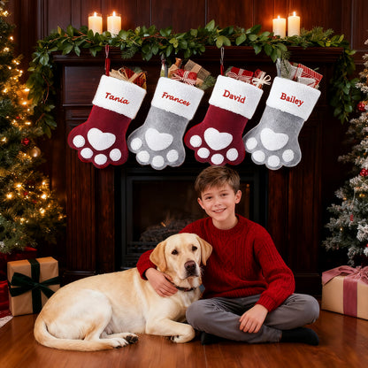 Boy with dog in front of a fireplace with personalized Christmas stockings.