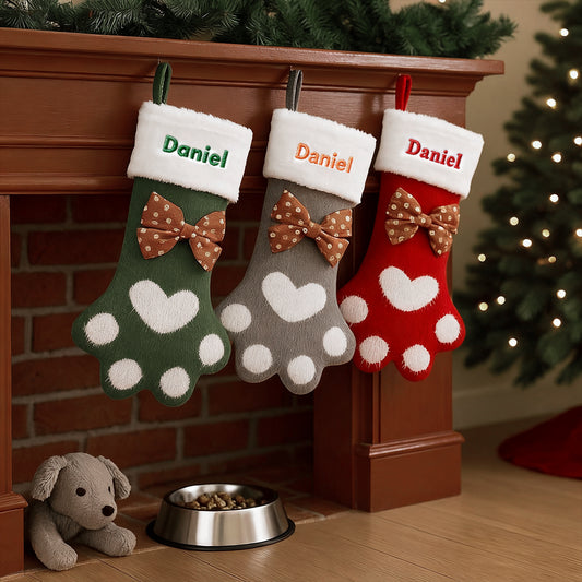 Three Christmas stockings with 'Daniel' on them hanging by a fireplace.img