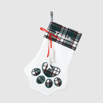 White Christmas stocking with plaid accents and paw print design on a light gray background