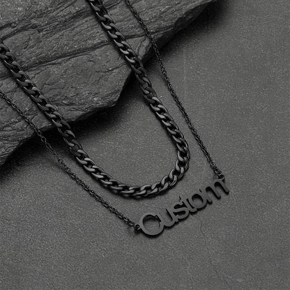 Black chain necklace with 'Custom' pendant on a dark stone surface