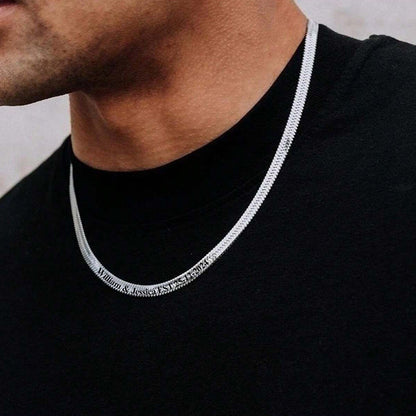 Man wearing a black shirt with a silver chain necklace.