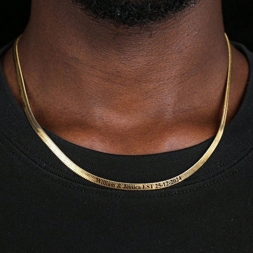 Gold necklace worn by a person on a black background