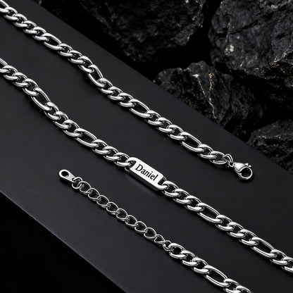 Silver chain necklace with 'Daniel' engraving on a dark surface