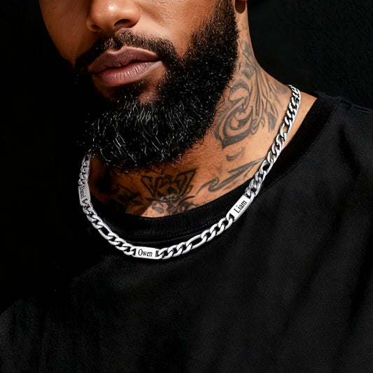 Man wearing a silver chain necklace with tattoos on his neck against a black backgroundimg