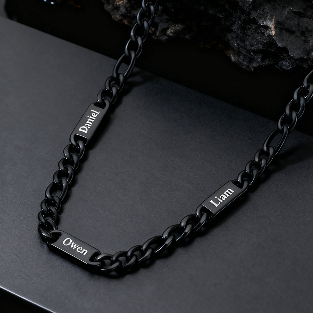 Black chain bracelet with engraved names on a dark surface