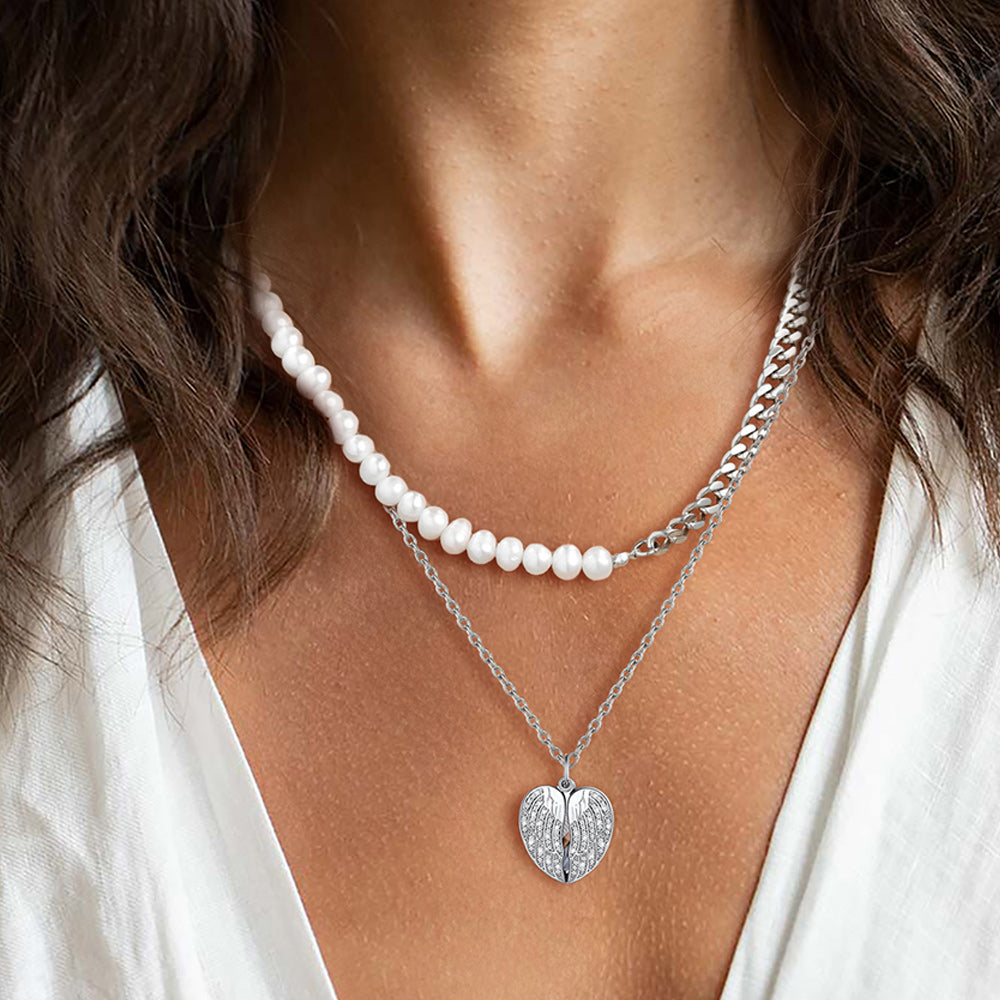 Close-up of a woman wearing a pearl necklace and a silver heart-shaped pendant.