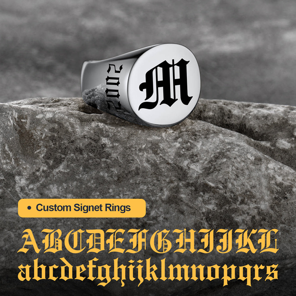 Silver signet ring with letter 'M' on a stone surface, featuring text about custom signet rings.
