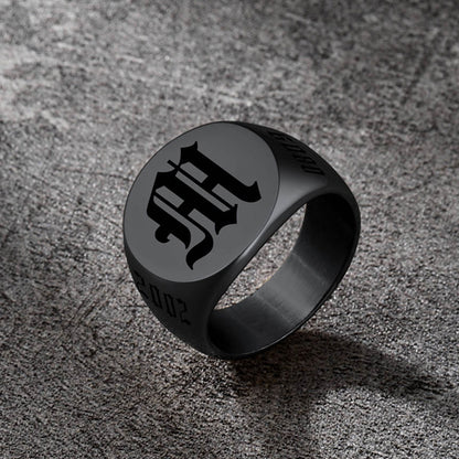 Black ring with a symbol on a textured gray surface