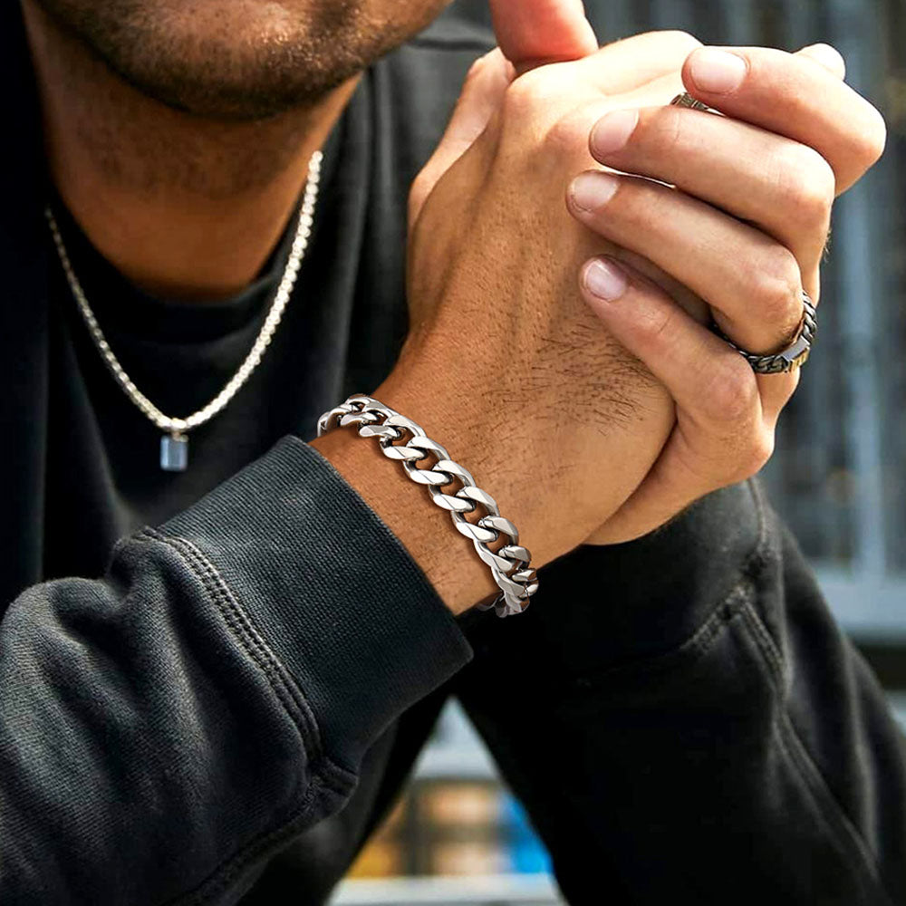 Person wearing a silver chain bracelet and ring with blurred background