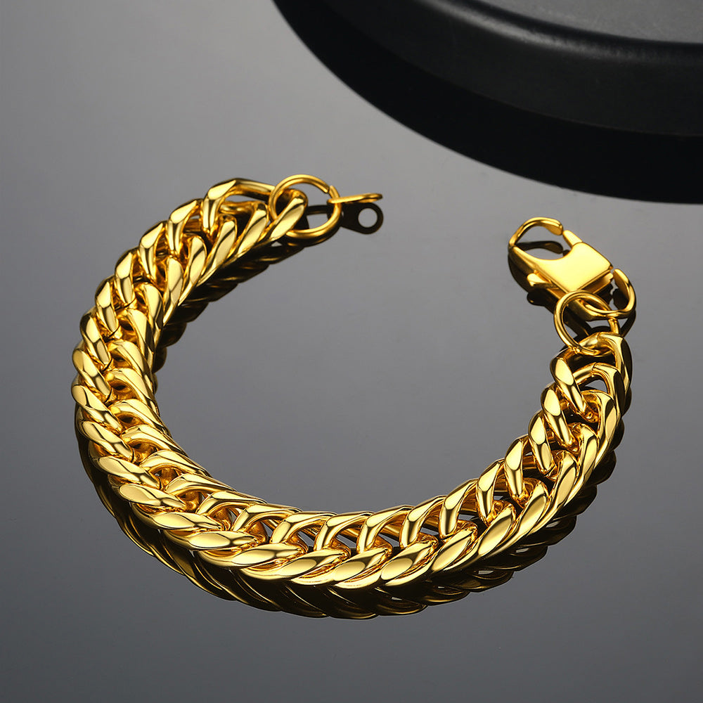 Gold chain bracelet on a reflective black surface