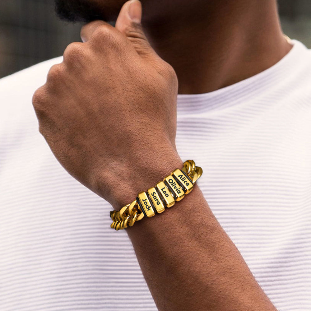 Gold bracelet with engraved text on a person's wrist against a white background