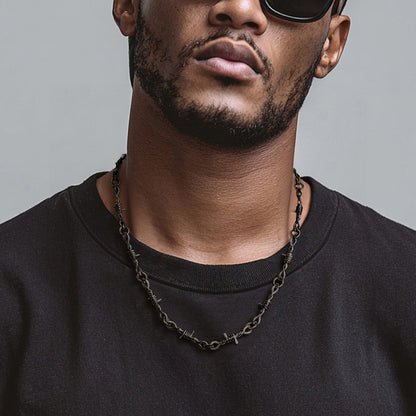 Man wearing a black shirt and sunglasses with a gray background