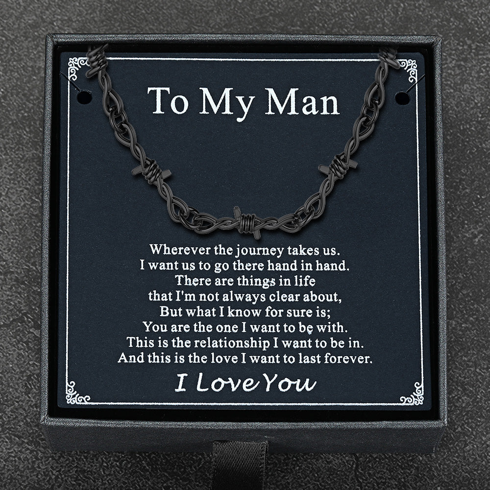 Flat lay of barbed wire chain with gift packaging and punk-themed card