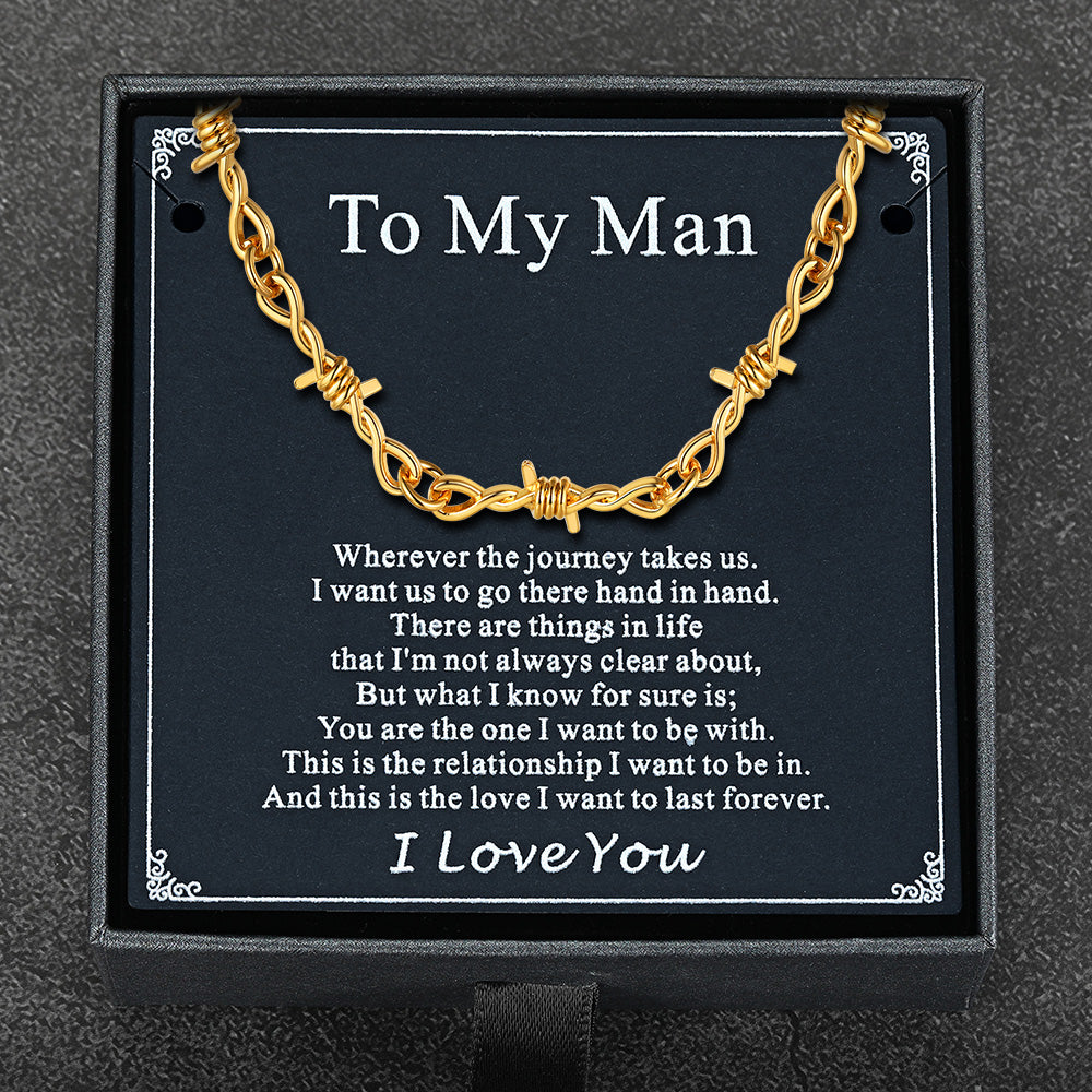 Flat lay of barbed wire chain with gift packaging and punk-themed card