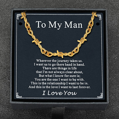 Flat lay of barbed wire chain with gift packaging and punk-themed card