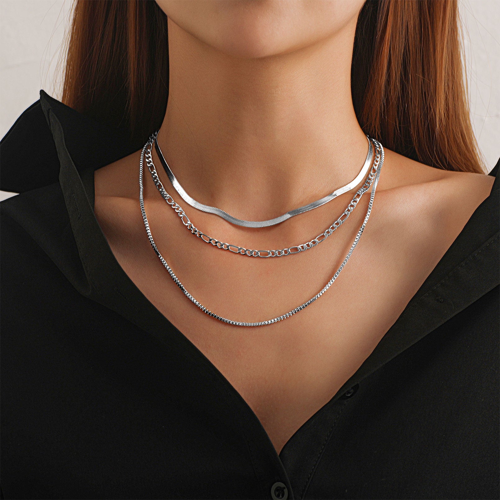 Silver necklaces on a model wearing a black shirt