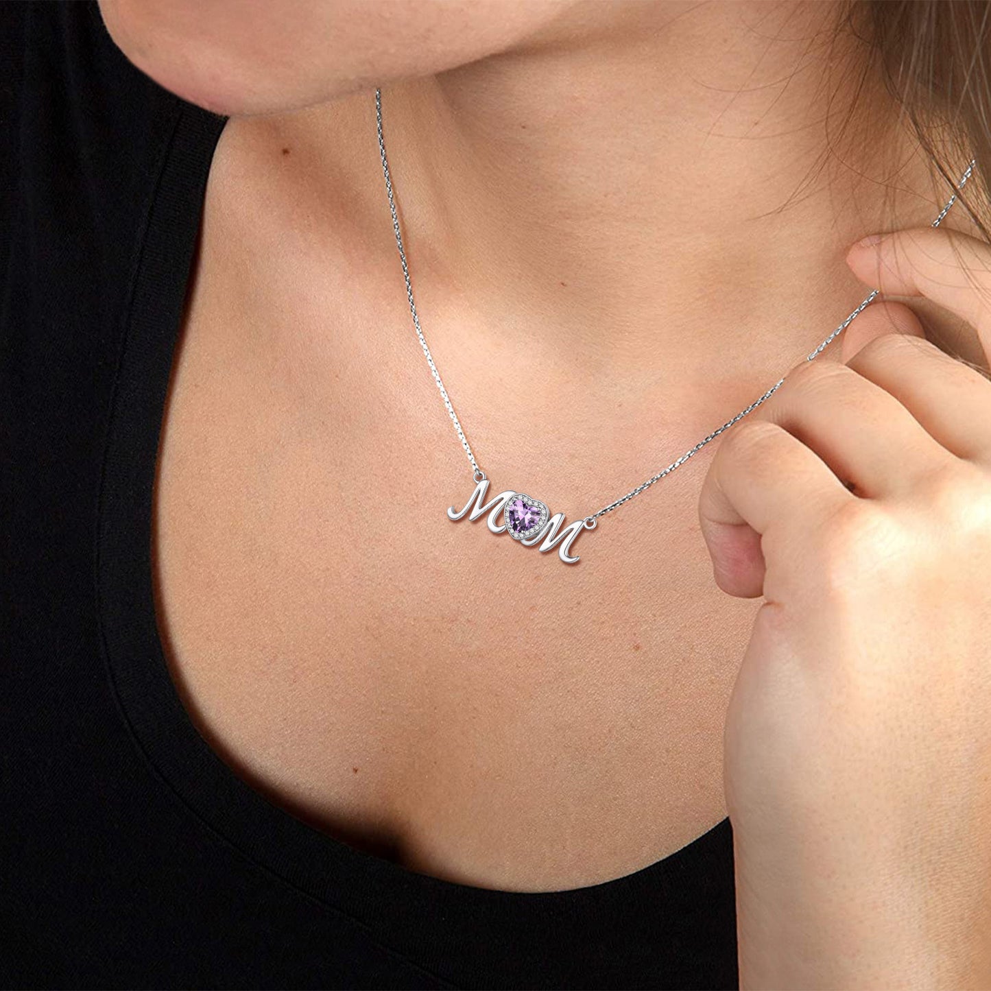 Necklace with 'mom' pendant on a person wearing a black top