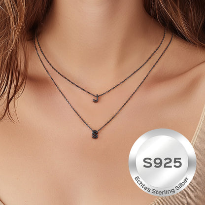 Necklace with letter pendants on a model's neck, featuring 'S925' stamp.