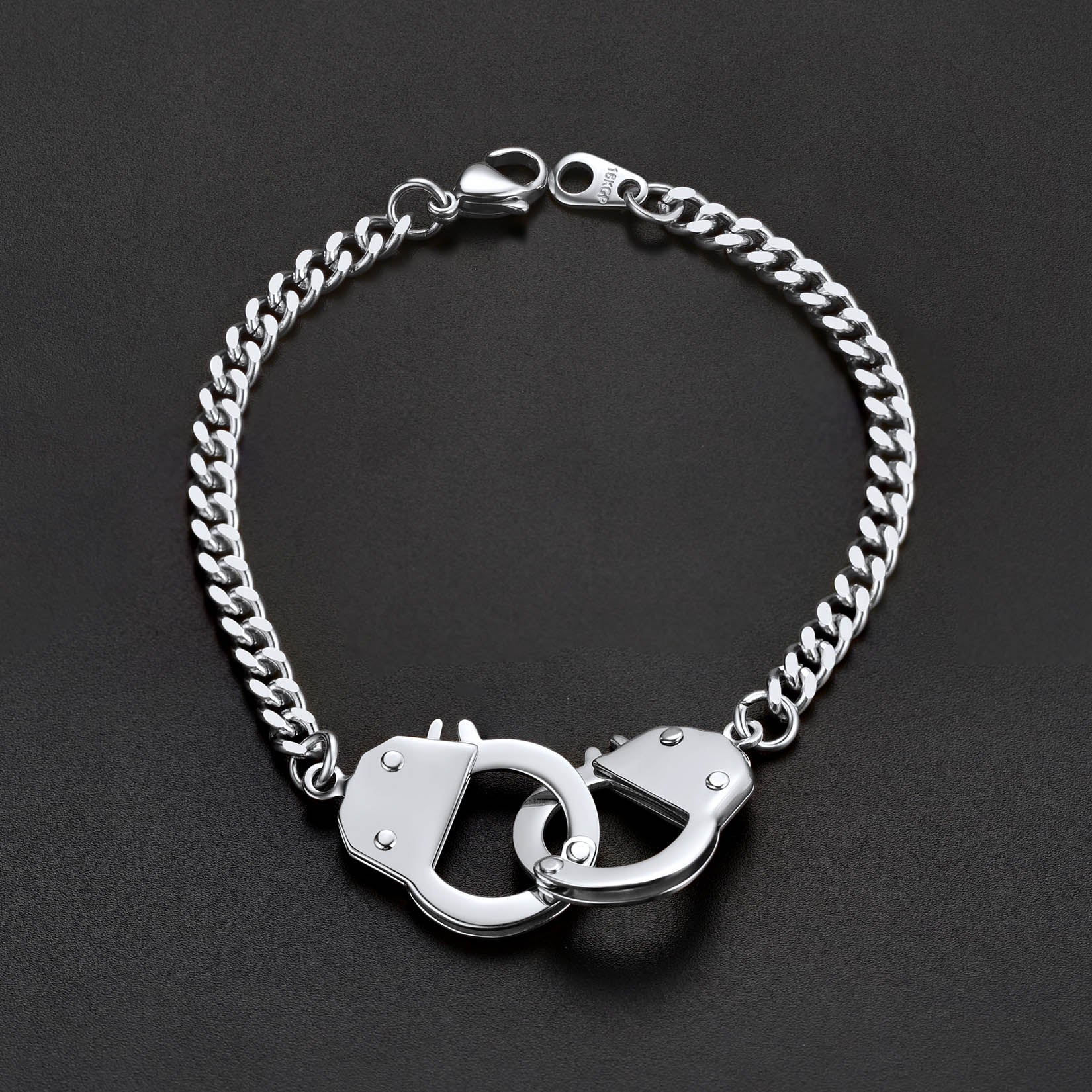 Silver chain bracelet with handcuff links on a black background