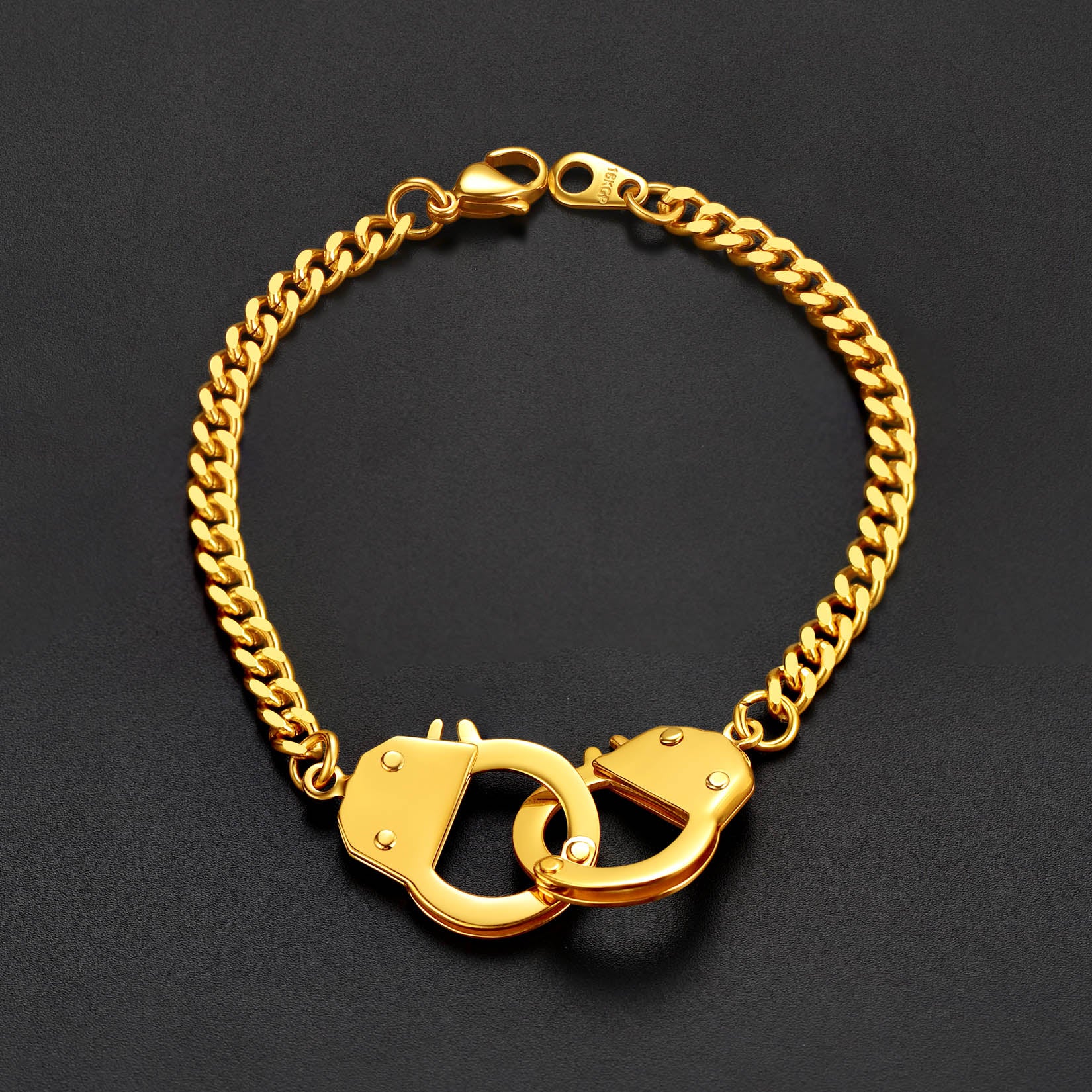 Gold chain bracelet with handcuff links on a black background