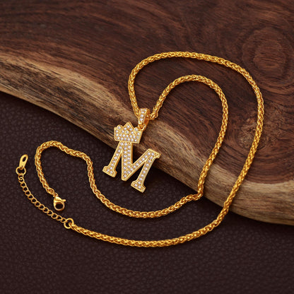 Gold necklace with a 'M' pendant on a wooden surface