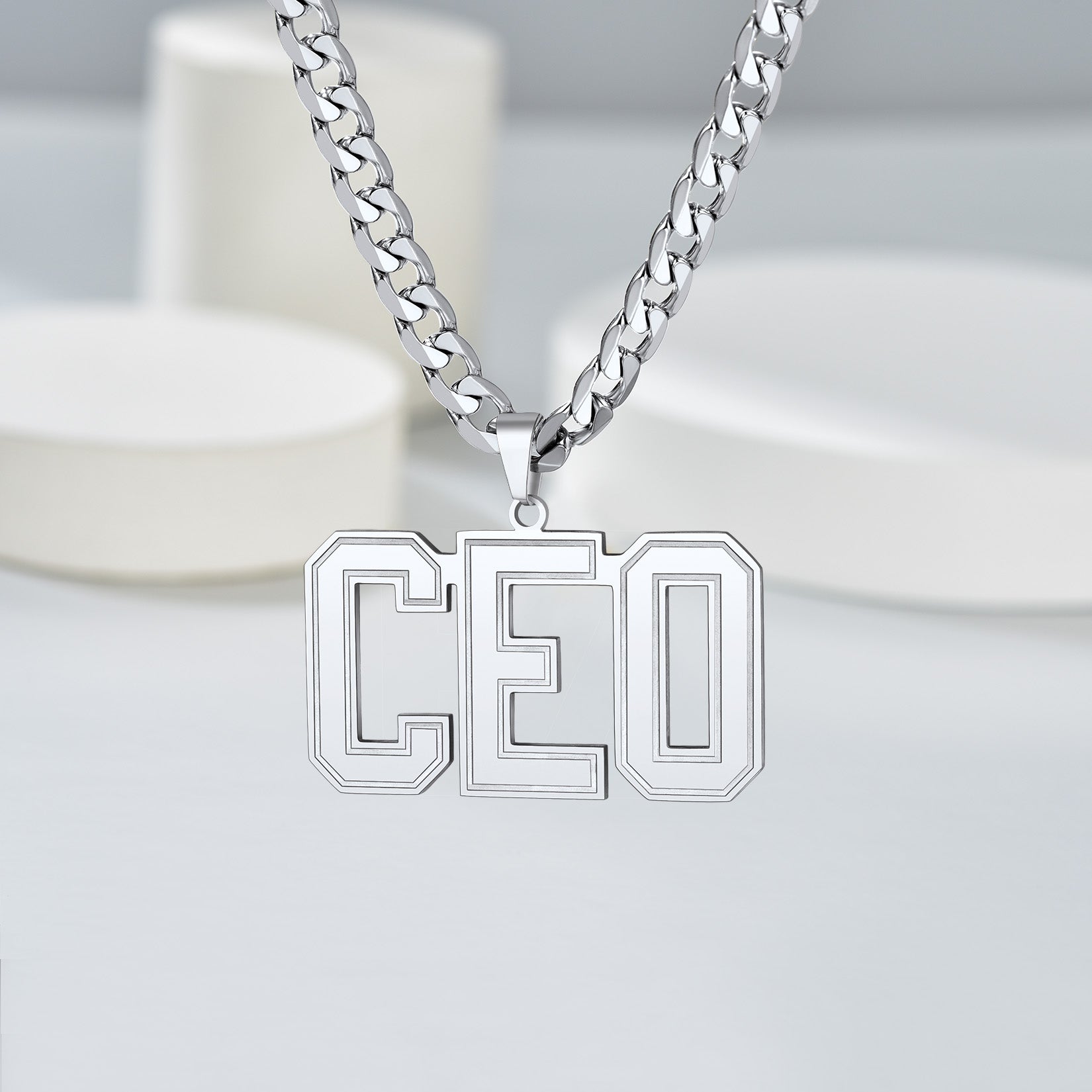 Silver Initial Letter Necklace with 'CEO' pendant on a light gray background