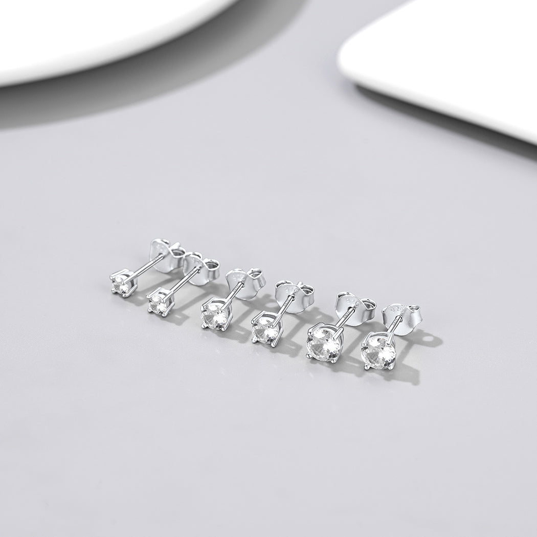 Set of silver earrings on a light gray surface