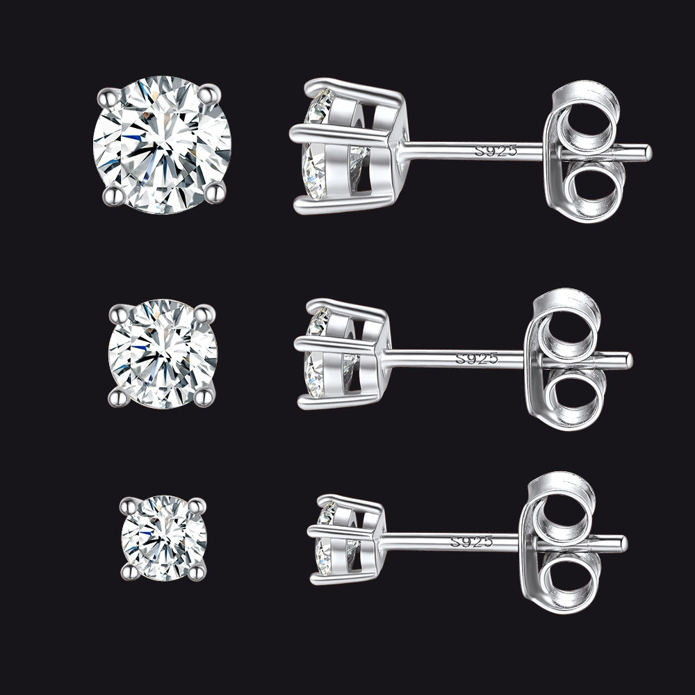Set of silver diamond stud earrings on a black background