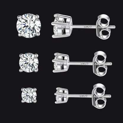 Set of silver diamond stud earrings on a black background