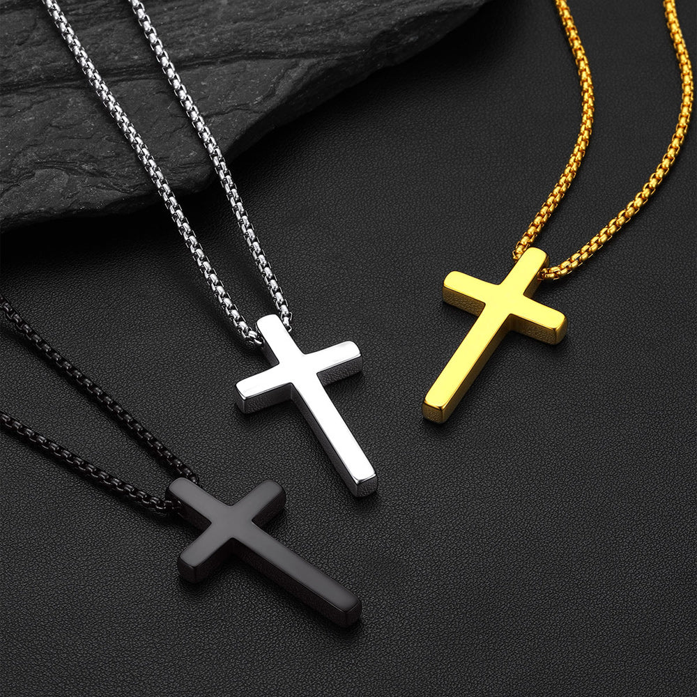 Three cross-shaped pendants on chains against a dark background