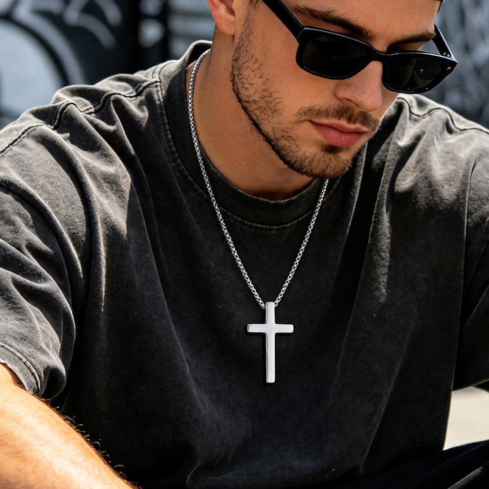 Man wearing a black t-shirt and sunglasses with a cross necklace.