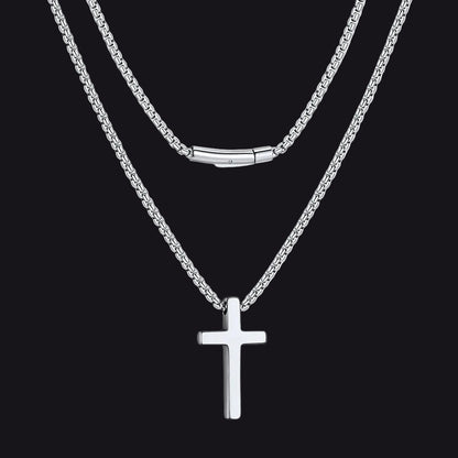 Silver cross necklace on a black background