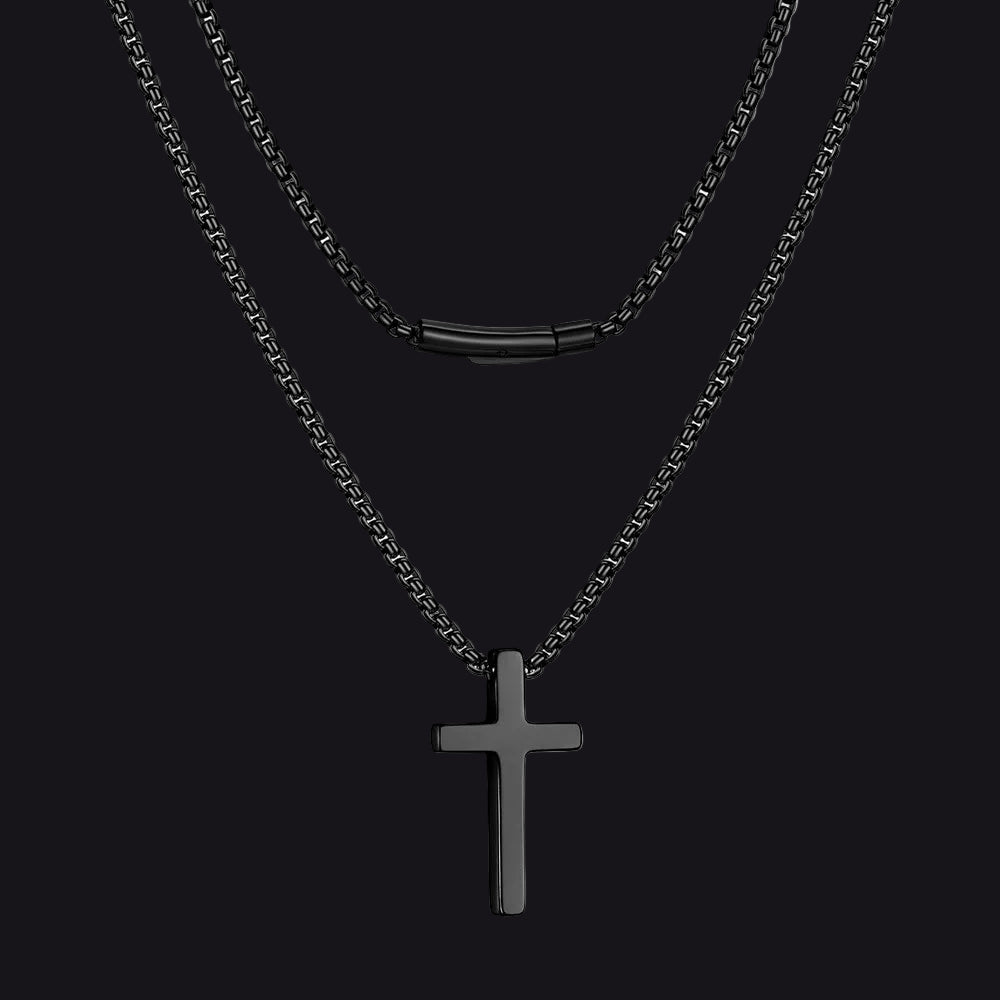 Black cross pendant necklace on a black background