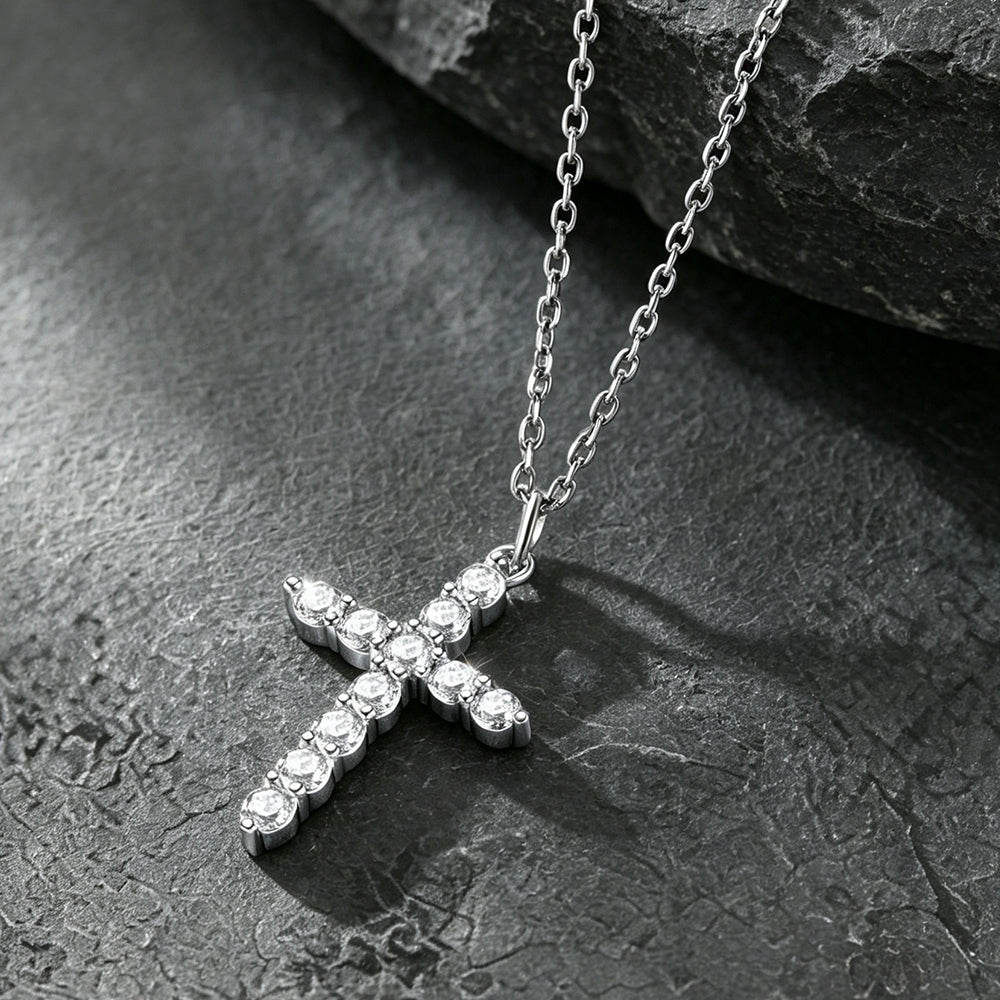 A silver cross pendant necklace adorned with small clear stones.