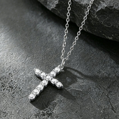 A silver cross pendant necklace adorned with small clear stones.