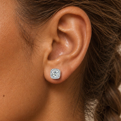 A woman's ear wearing a small round stud earring with clear stones.